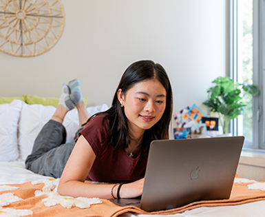 Tenant laying on their bed with their laptop