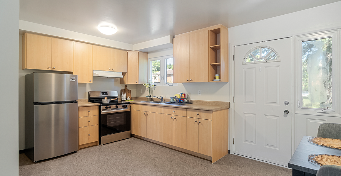 Kitchen showing fridge, oven and cabinets