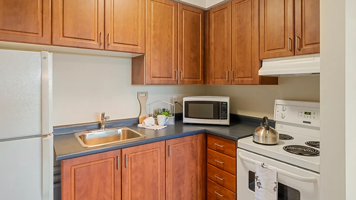 Kitchen showing fridge, oven, cabinets and sink